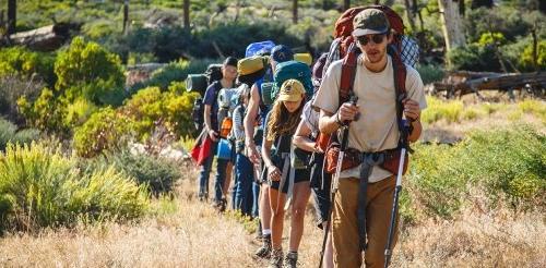 several pitzer students hike up a hill during an orientation adventure